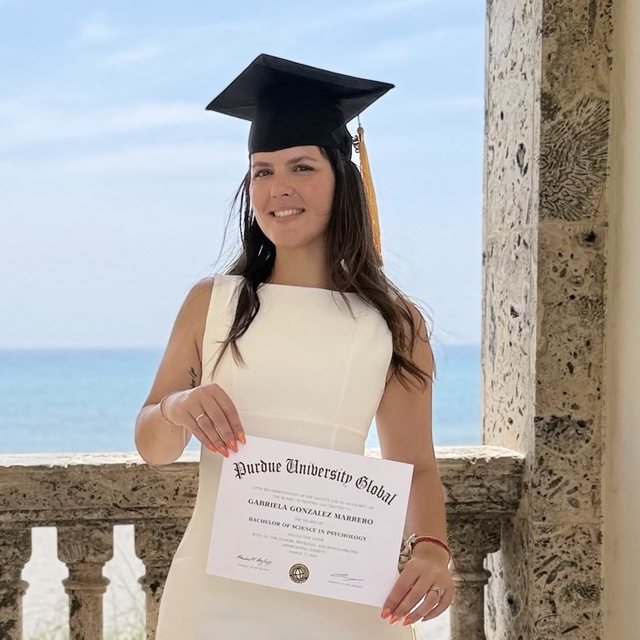 Gabriela Gonzalez holding her Purdue University Global diploma